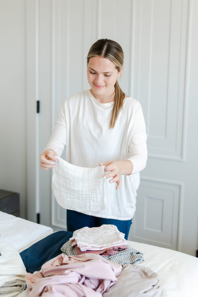 postpartum doula folding baby laundry